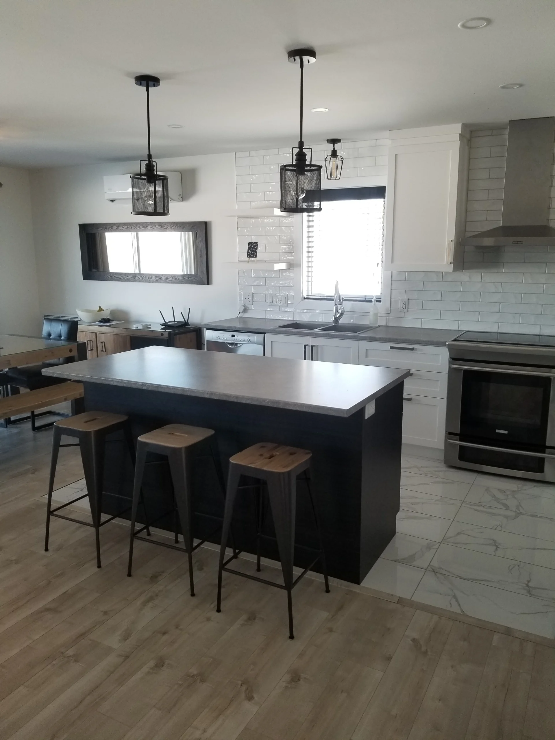 Cuisine avec un luminaire moderne suspendu au plafond, rénovée par Urbano Constructtion.