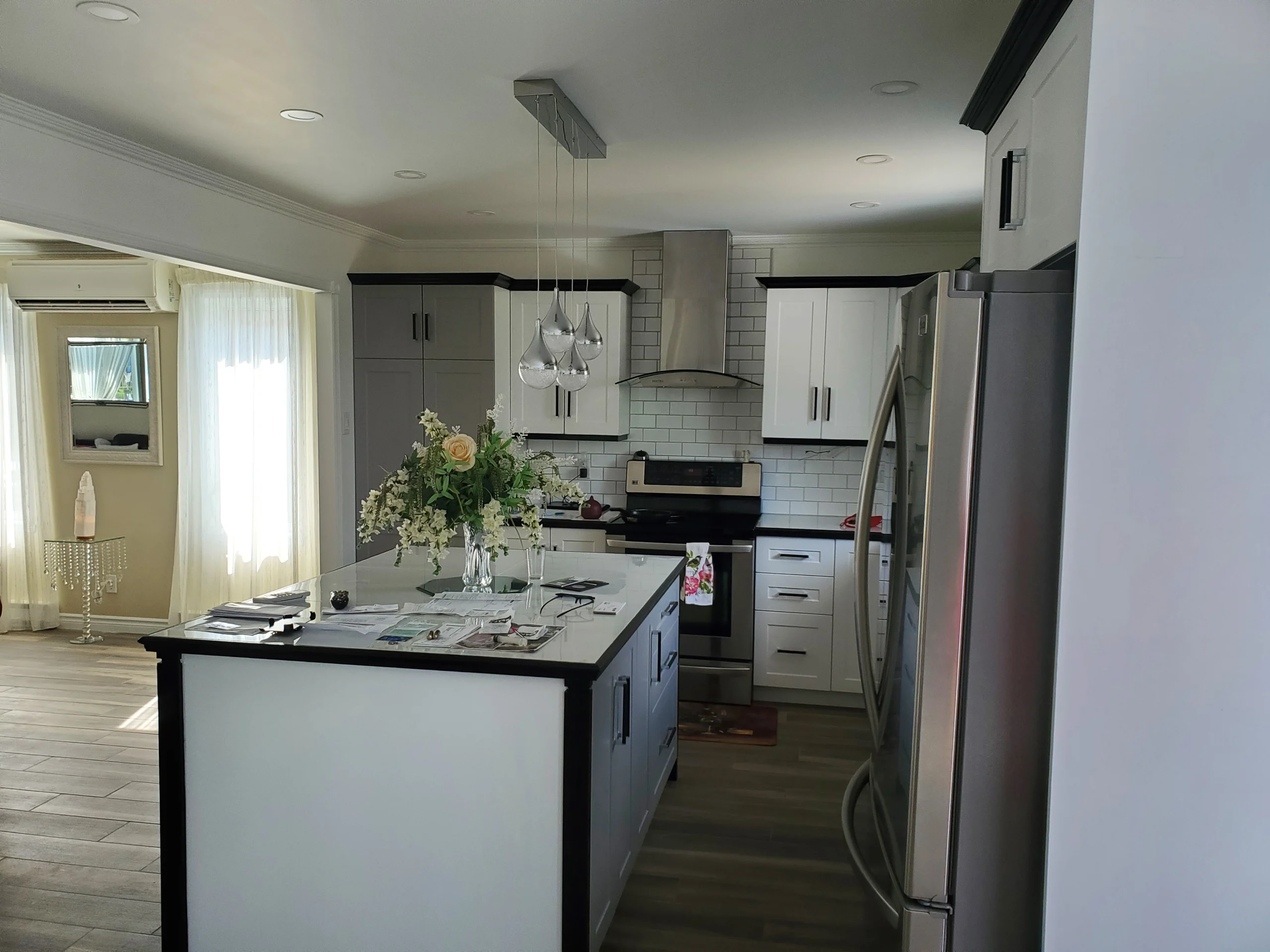 Cuisine avec un luminaire moderne suspendu au plafond, rénovée par Urbano Constructtion.